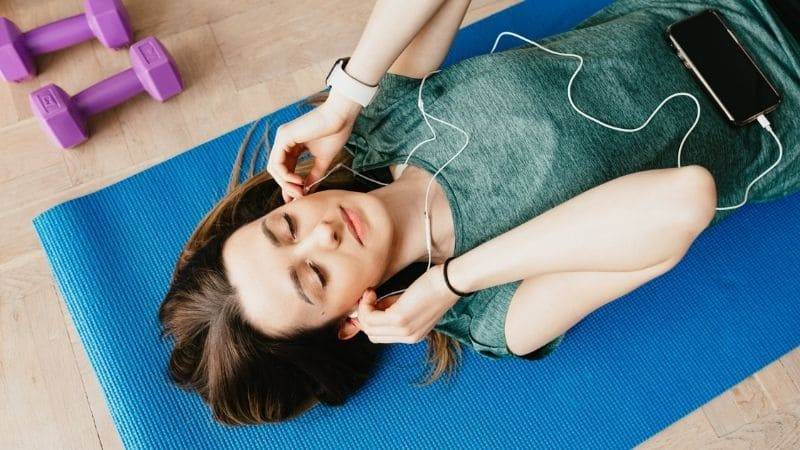 Woman listening on earphones to recharge Your Mental Health for 2022