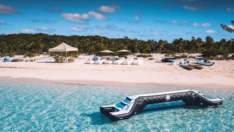 Water joust with a superyacht beach setup with loungers and kayaks