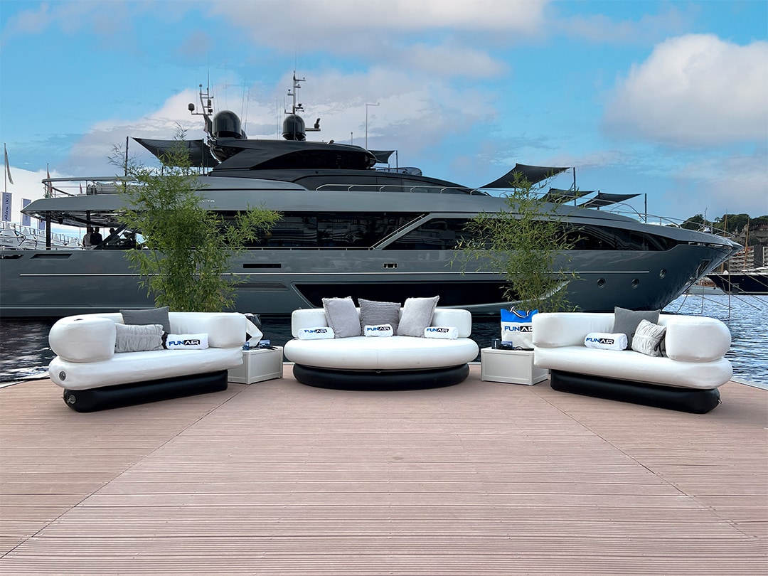 Club Chaise and Club Chairs on display at Monaco Yacht Show in front of a superyacht