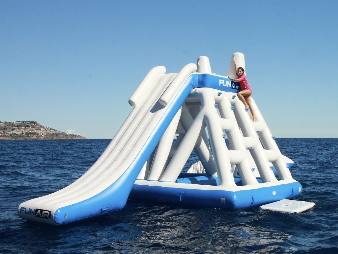A child climbing on a Floating Inflatable Playground at sea