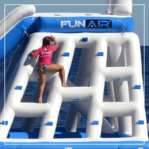 A girl using the thandles to climb an inflatable playground