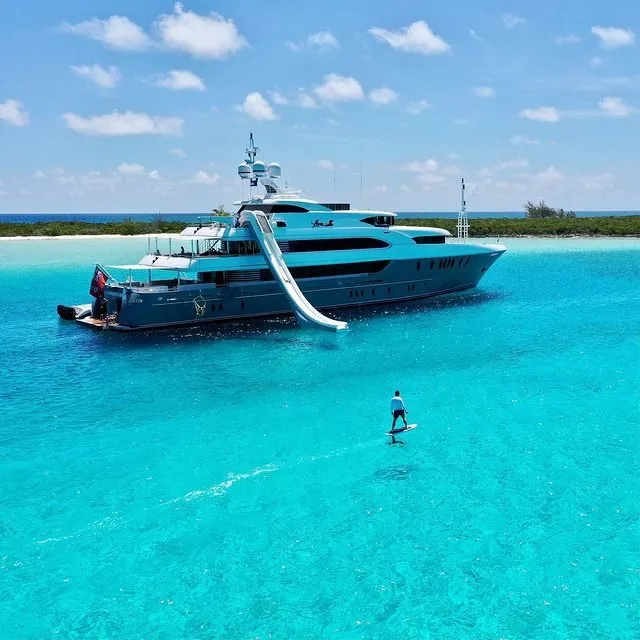 charter-guest-on-efoil-infront-of-Motor-Yacht-Loon-with-yacht-slide