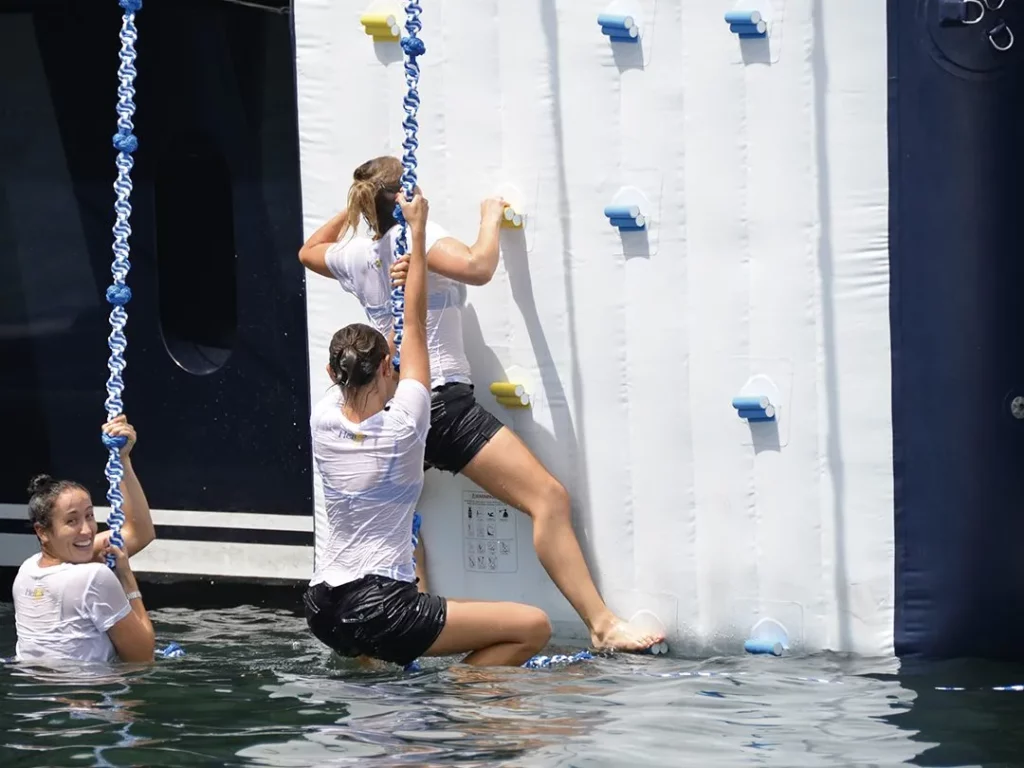 Guests on the inflatable climbing wall on a charter superyacht