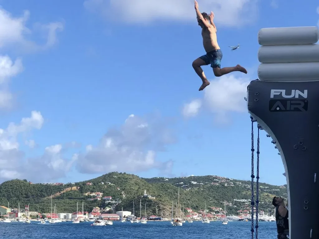Charter guest jumping from the Climbing Wall on Motor Yacht Gene Machine