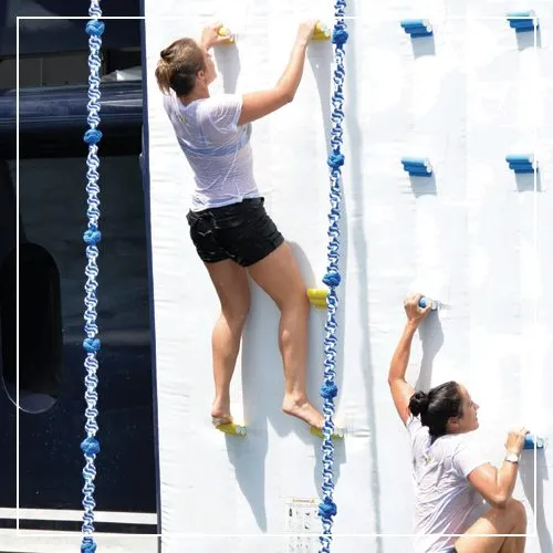 Charter guests using the ropes on a FunAir superyacht inflatable climbing Wall