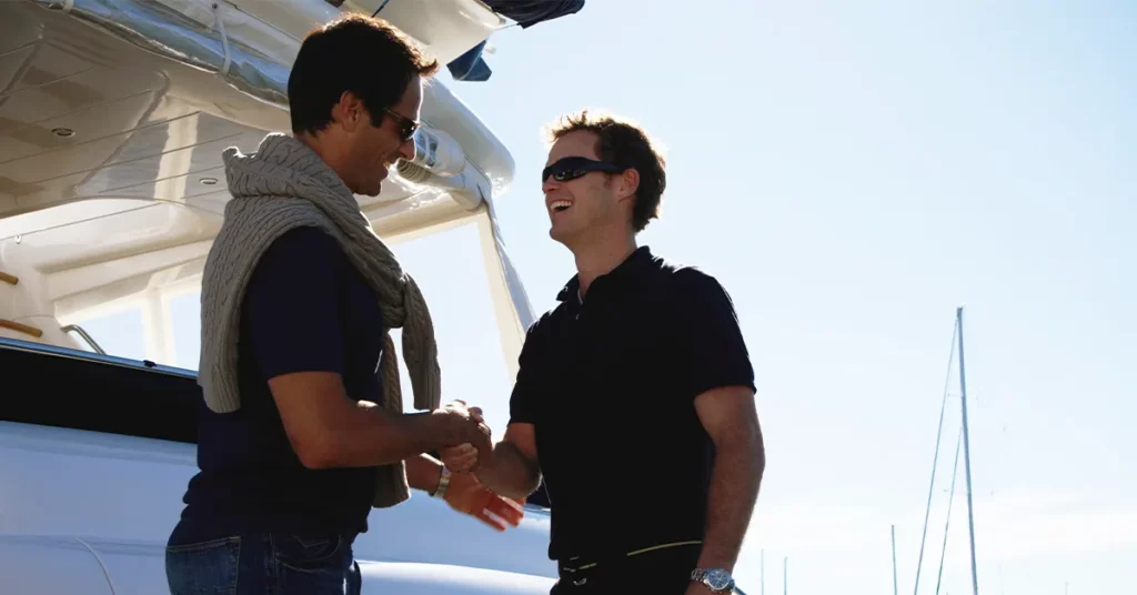 Yacht crew member shaking hands with a superyacht owner