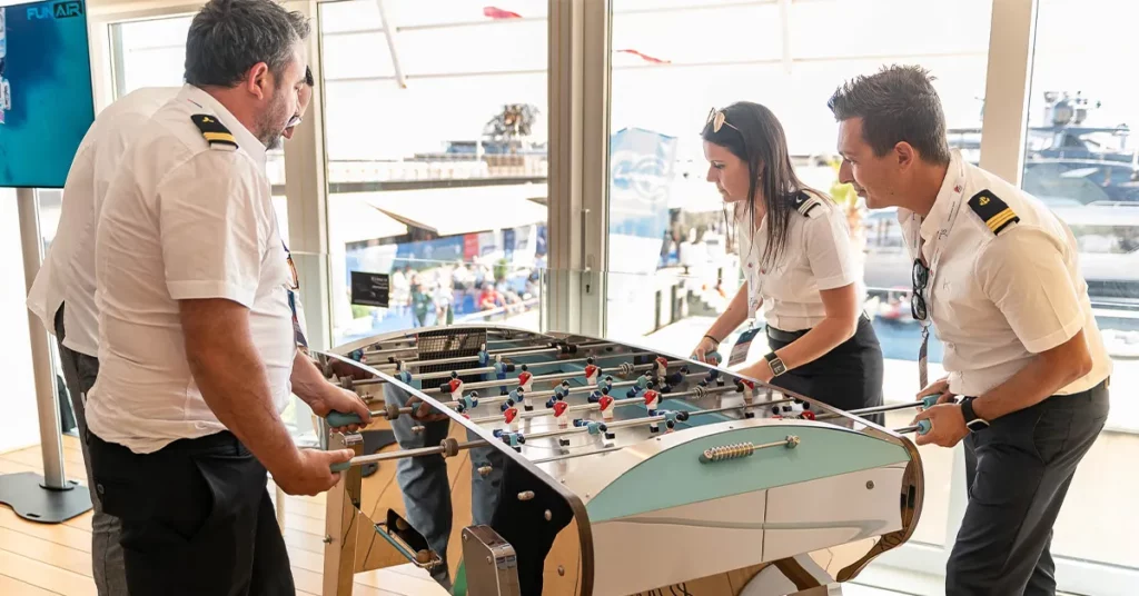 Yacht crew playing pub football in the Captains and Crew Lounge at Monaco Yacht Show