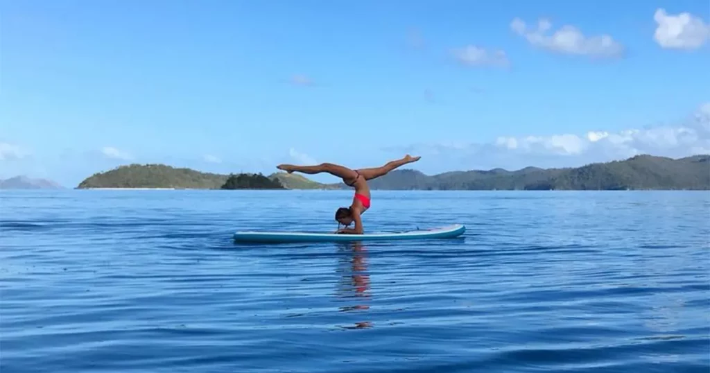 Charter superyacht crew doing yoga on a paddle board