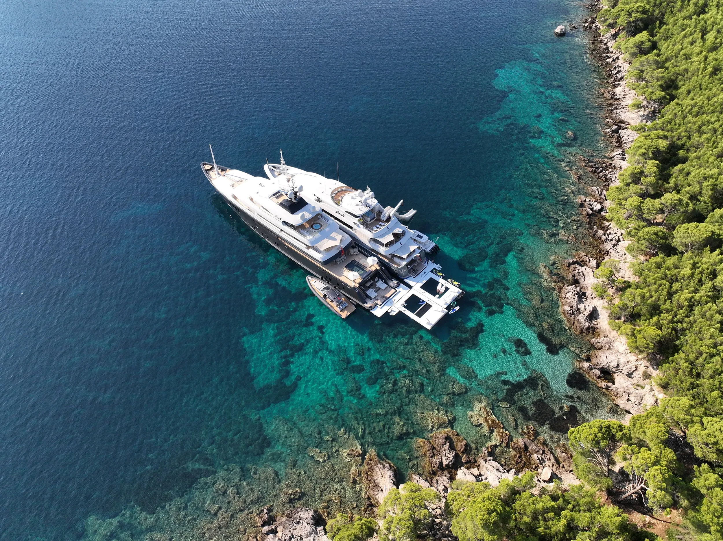 Sea Pool Yacht Slide Loungers MY Loon 221 and Loon 180 in tandem in Croatia overhead view anchored off rocky coast