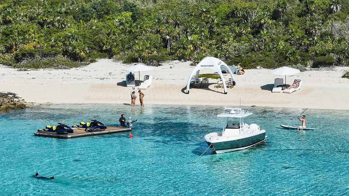 Wave Loungers from charter superyacht No Bad Ideas distance shot from drone of beach set up with tender jet skis and kayak