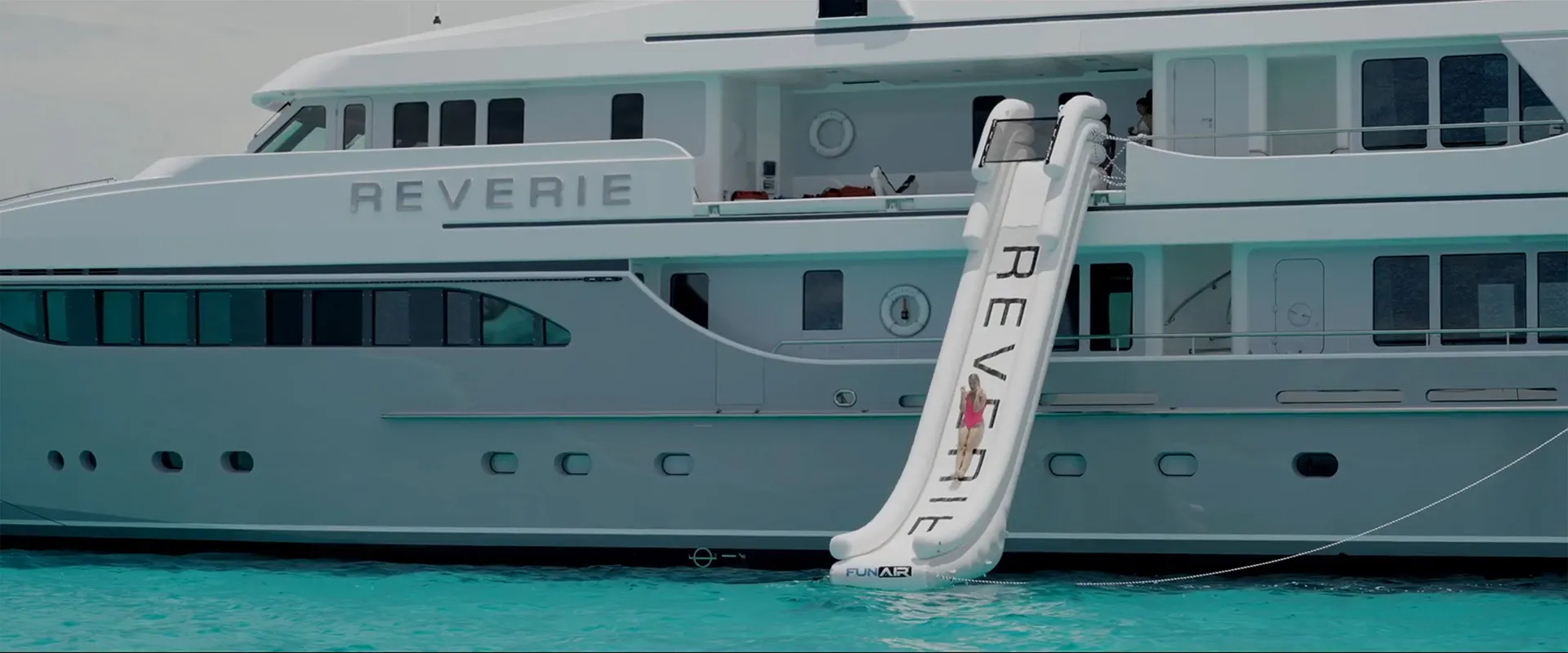 Yacht Slide on superyacht MY Reverie female charter guest on slide side