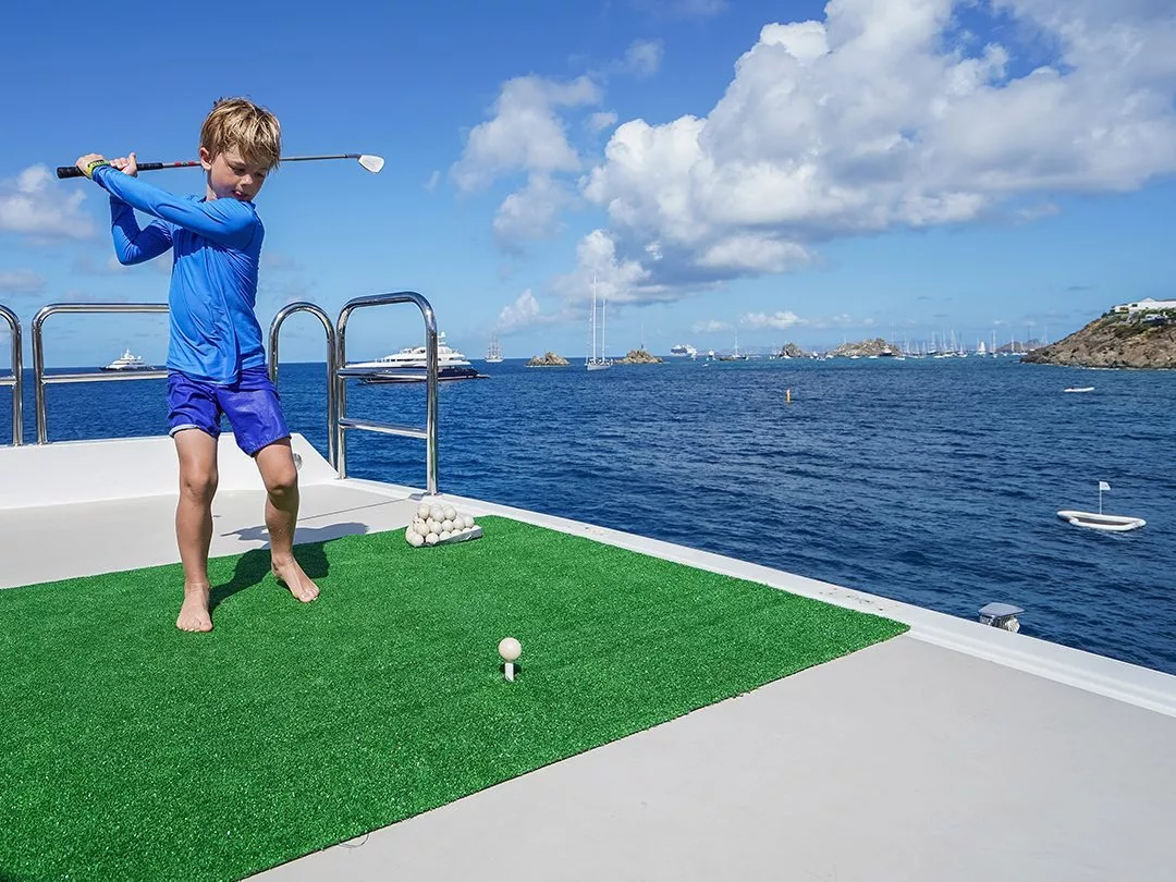 Young guest from a charter superyacht playing Yacht Golf
