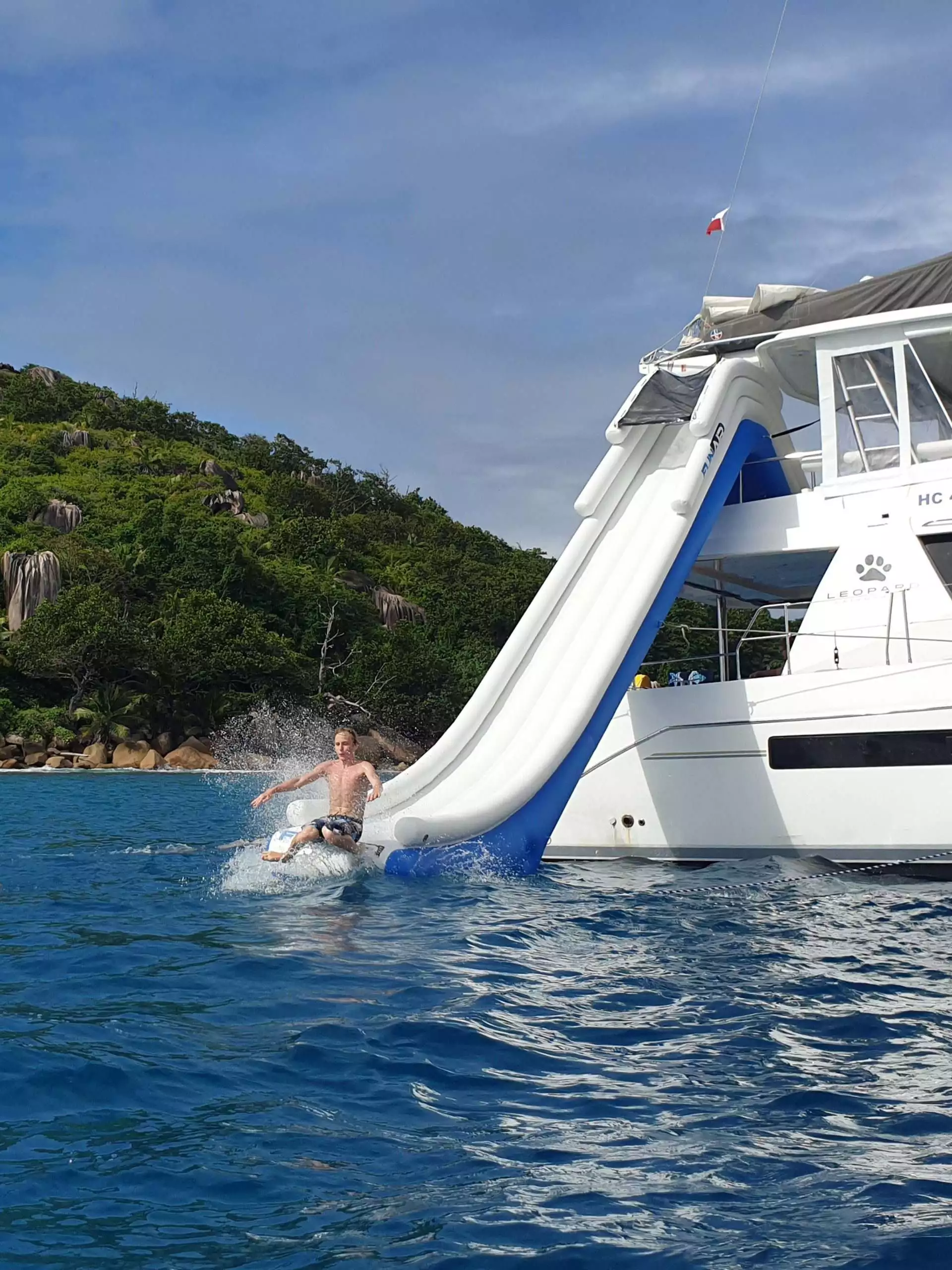 Young male charter guest using the Yacht Slide on superyacht Leopard