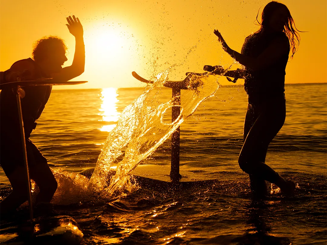 Charter yacht guests having fun with their Fliteboards in the ocean at sunset