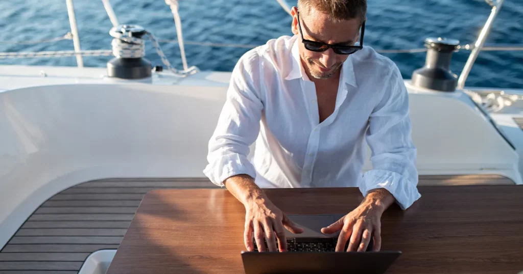Crew member from charter yacht applying for jobs on a laptop