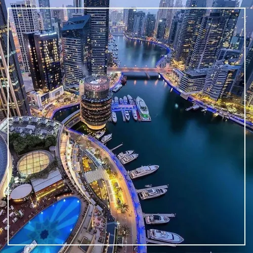 Drone view of superyachts in a city centre marina at night
