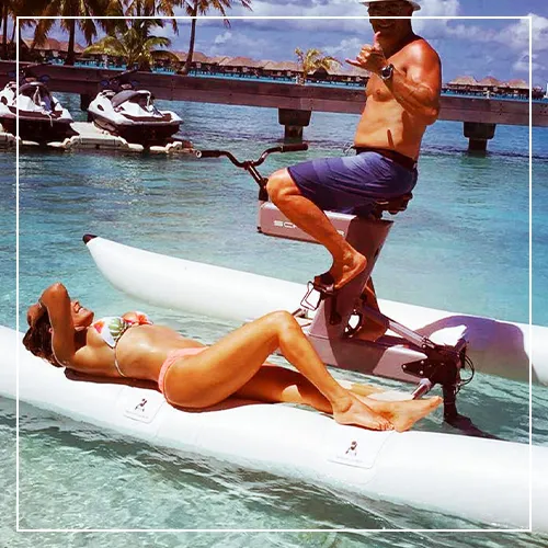 Guests from a luxury superyacht relaxing on a Schiller bike next to a tropical beach