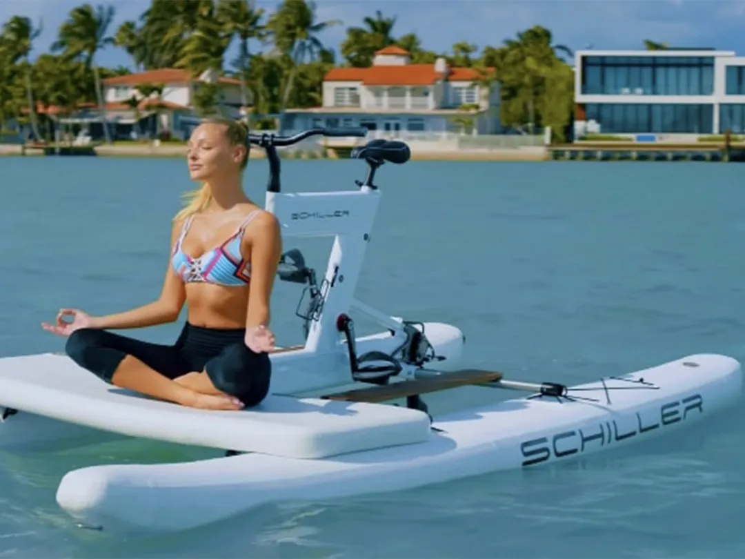 Woman superyacht charter guest doing yoga on a Schiller Bike on the water