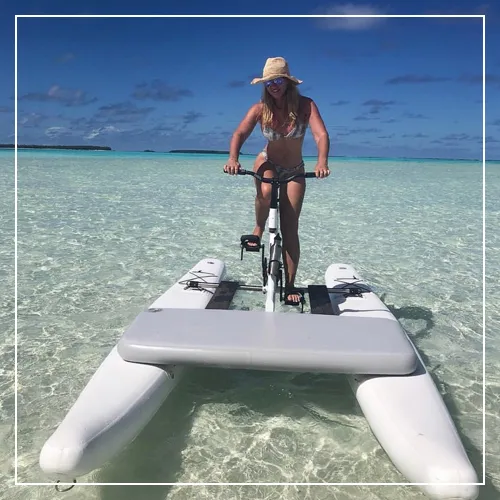 Superyacht charter guest riding a Schiller bike in a crystal clear ocean