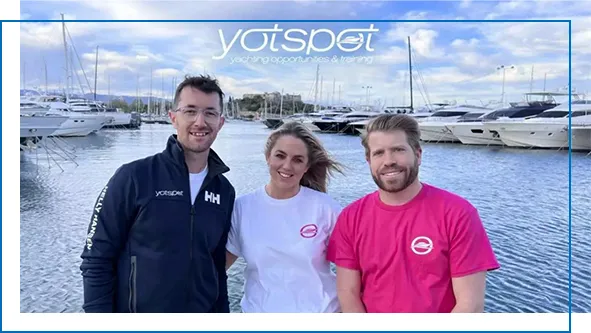 YotSpot team members in a superyacht harbour with yachts in the background