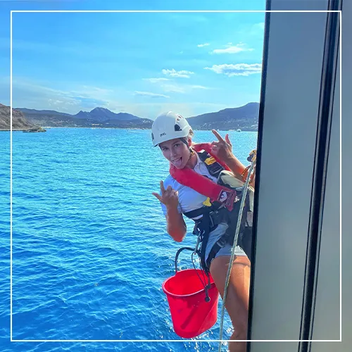 happy crew member in a harness maintaining a superyacht