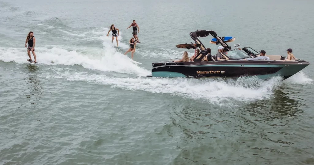 Charter guests wake boarding behind a MasterCraft tender