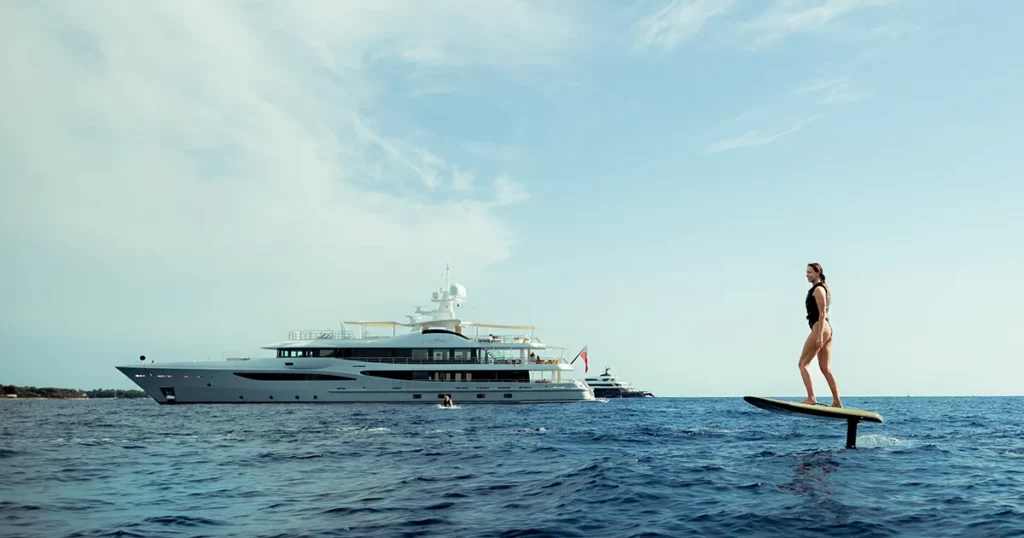 Superyacht charter guest riding a Fliteboard in front of the yacht