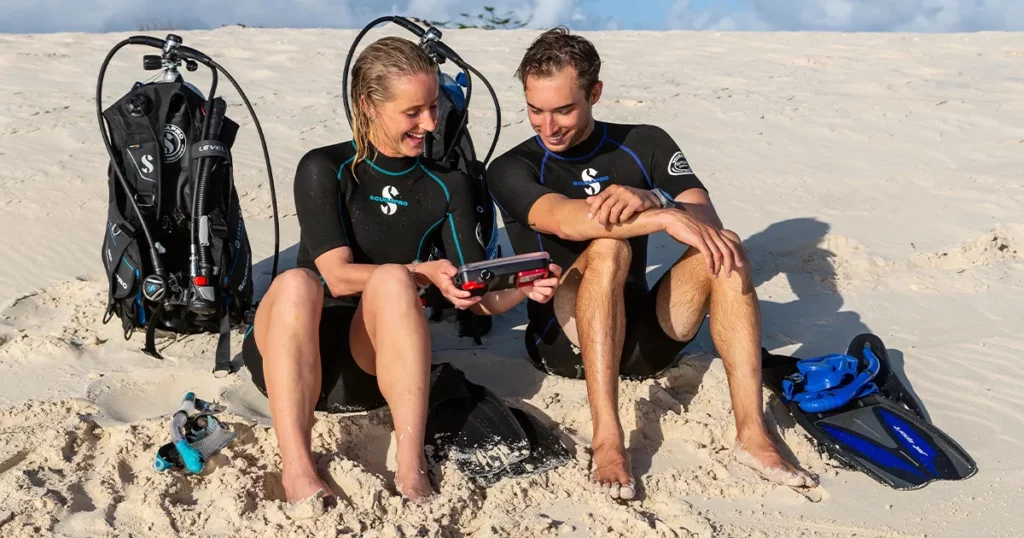 Superyacht charter guests wearing SCUBAPRO diving gear on a beach