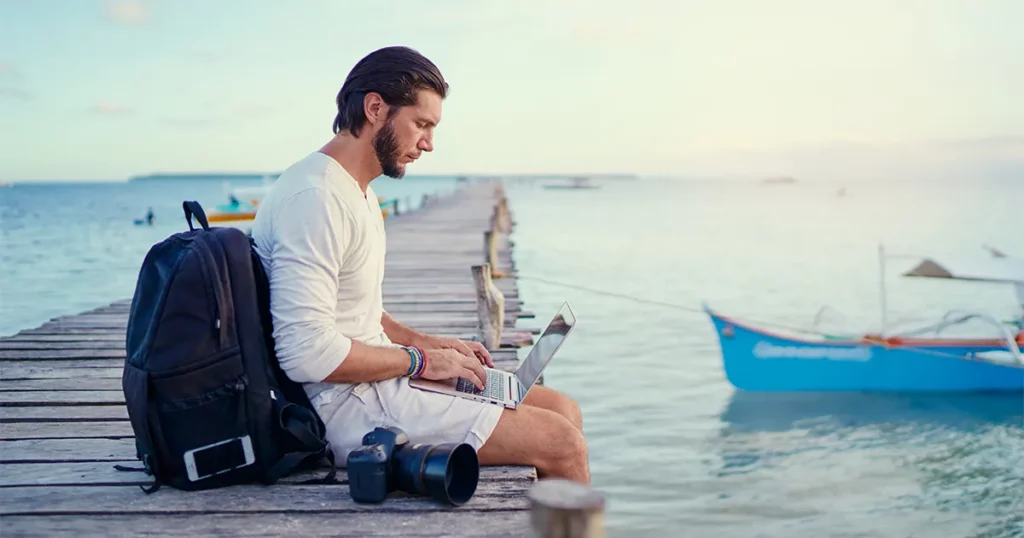 A member of superyacht crew checking emails on a pontoon