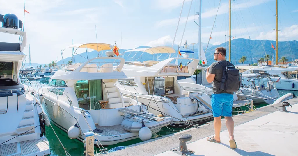 Superyacht crew steward visiting yachts in a luxury yacht marina
