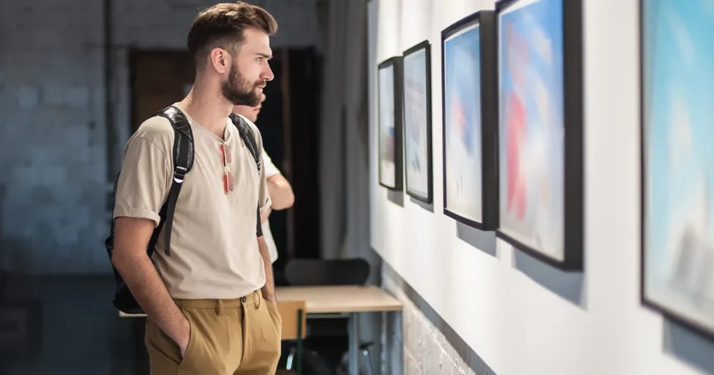 superyacht crew member looking at art in a gallery in the south of france