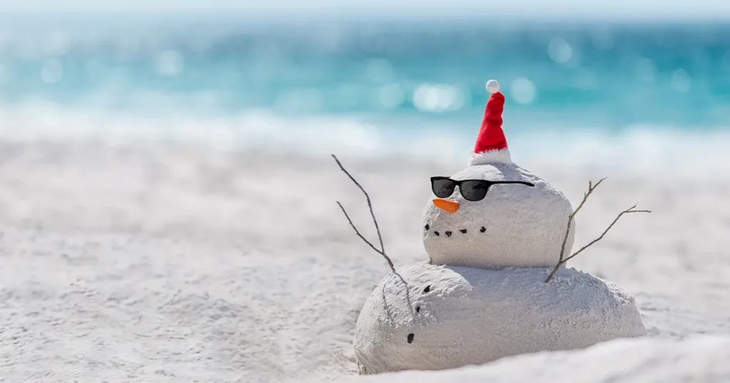 christmas snowman in festive hat made of sand on a caribbean beach